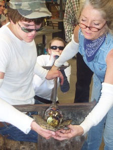 [Glassblowing Photo 225x300] Forming hot glass on a blow pipe.